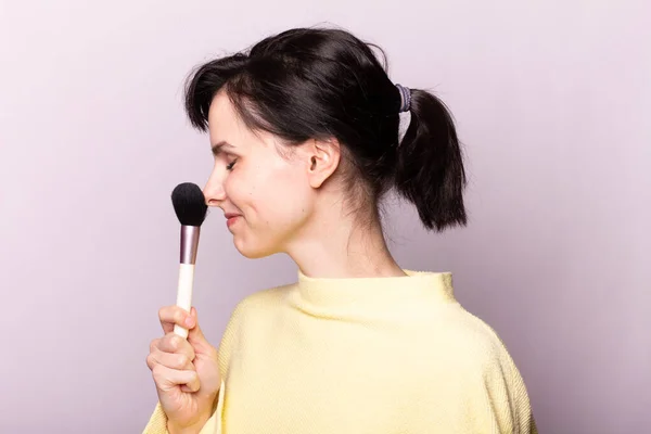 Attraktiv Pige Gul Sweater Gør Makeup Med Børste - Stock-foto