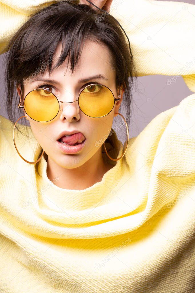 beautiful girl in yellow glasses and a yellow sweater