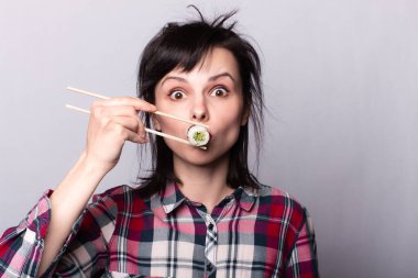 Elinde yemek olan bir kadın. Çubuklardaki suşi