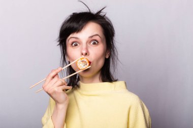Kadının elinde çubuk suşi Japon Asya 'sını sarıyor.
