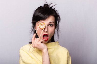 Suşi yiyen ve arka planda yuvarlanan bir kadın