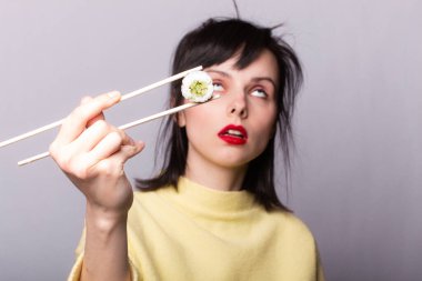 Kadın yemek çubuklarıyla suşi yiyor, rulo, Asya, Japonya