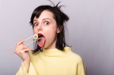 Kadın yemek çubuklarıyla suşi yiyor, rulo, Asya, Japonya