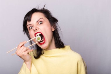 Kadın yemek çubuklarıyla suşi yiyor, rulo, Asya, Japonya