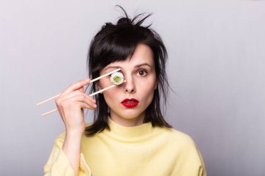 Suşi yiyen ve arka planda yuvarlanan bir kadın