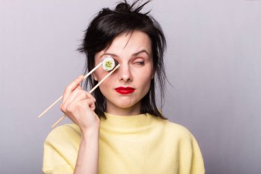 Suşi yiyen ve arka planda yuvarlanan bir kadın