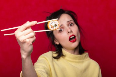 Kadın yemek çubuklarıyla suşi yiyor, rulo, Asya, Japonya