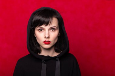 Dudaklarında kırmızı ruj lekesi olan siyah kazaklı bir kız.