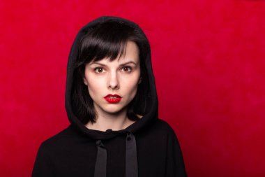 Dudaklarında kırmızı ruj lekesi olan siyah kazaklı bir kız.