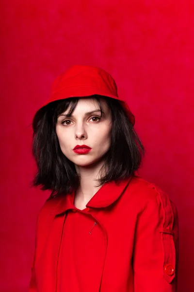 girl in red clothes with red lipstick on her lips, red background