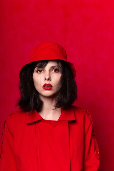 girl in red clothes with red lipstick on her lips, red background