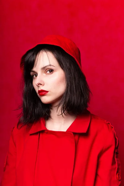 girl in red panama, red lipstick, red trench coat, red background