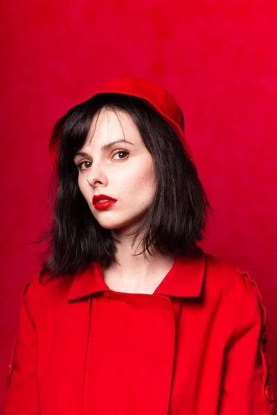 girl in red panama, red lipstick, red trench coat, red background