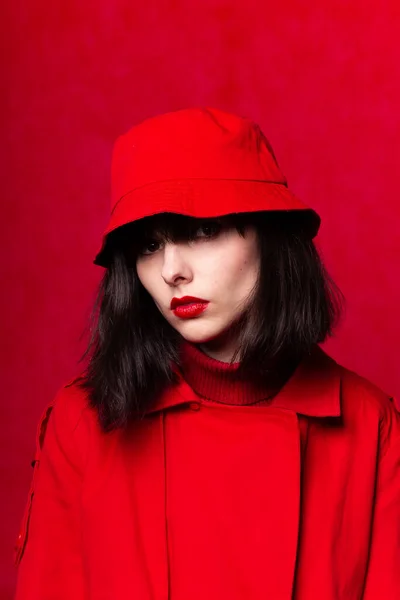 girl in red clothes with red lipstick on her lips, red background