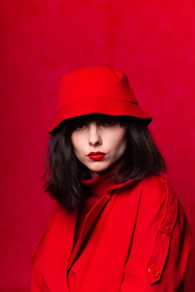 girl in red clothes with red lipstick on her lips, red background