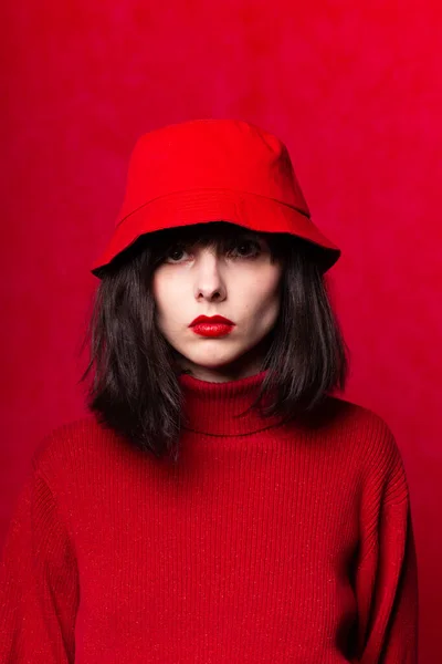 girl in red clothes with red lipstick on her lips, red background