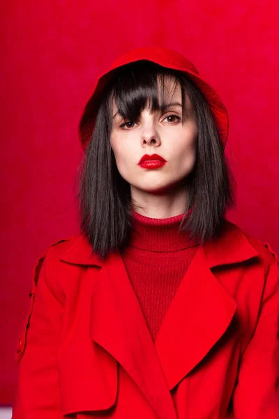 girl in red clothes with red lipstick on her lips, red background