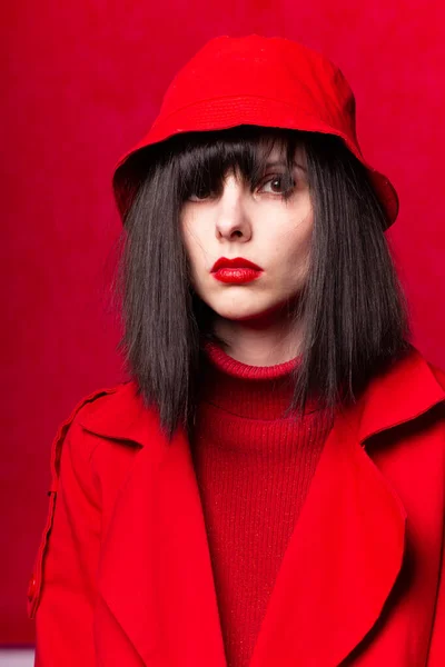 girl in a red sweater and red cloak, red background