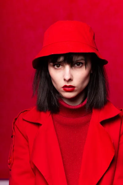 girl in a red sweater and red cloak, red background