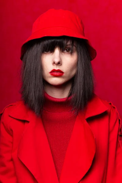 girl in a red sweater and red cloak, red background