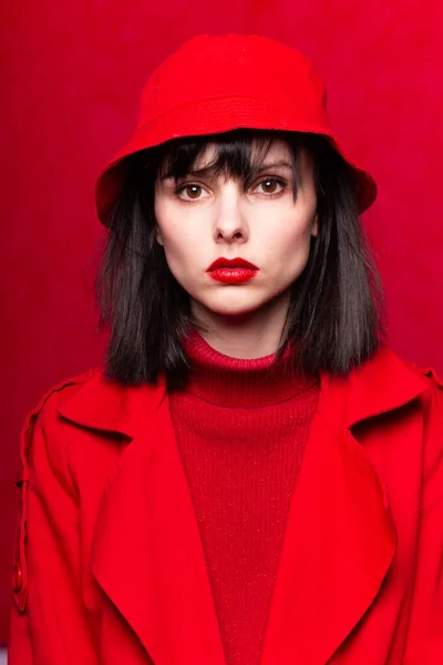 girl in a red sweater and red cloak, red background