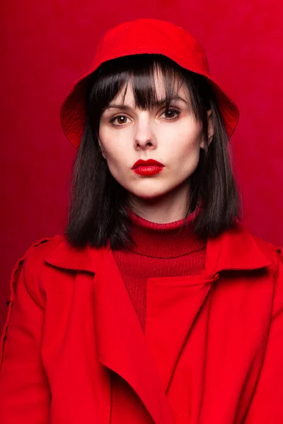 woman with bangs in red clothes, red background