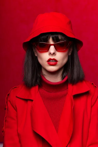 girl in a red panama hat, red background, close-up portrait