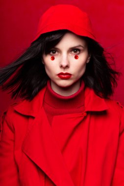 Bebek gibi kız, kırmızı arka plan, kırmızı kıyafetler, kırmızı dudaklar.