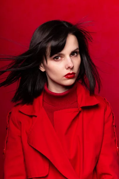 attractive girl in red clothes, red background