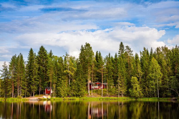 Red wooden cottage by the lake