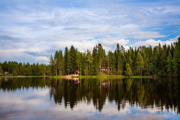 Red wooden cottage by the lake