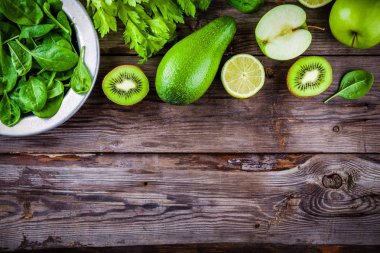 yeşil sebzeler: kivi, ıspanak, avokado, elma, limon, kereviz rustik ahşap arka plan üzerinde. Yukarıdan görüntülemek