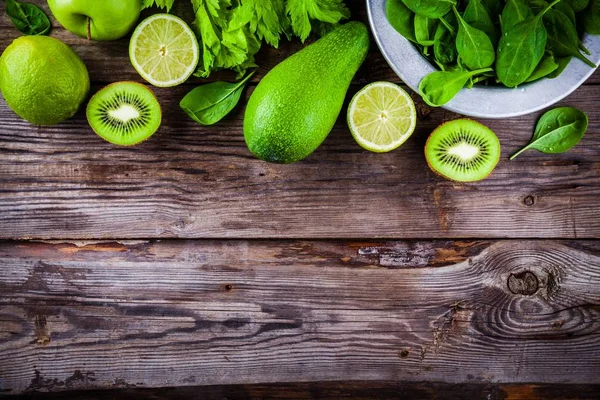 Green vegetables: kiwi, spinach, avocado, lime, celery on a rustic wooden background. view from above — Stock Photo, Image