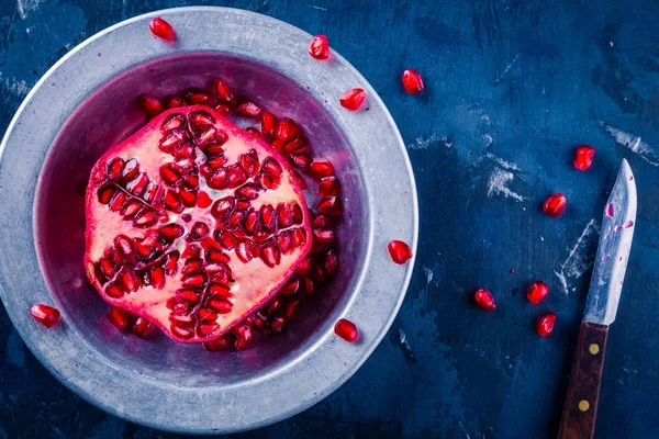 Bright juicy ripe pomegranate with seeds in a bowl — Stock Photo, Image