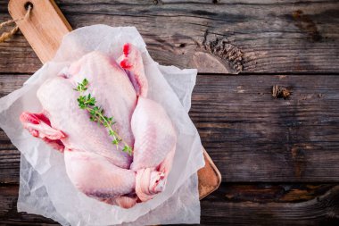 ahşap arka plan üzerinde organik çiğ bütün tavuk