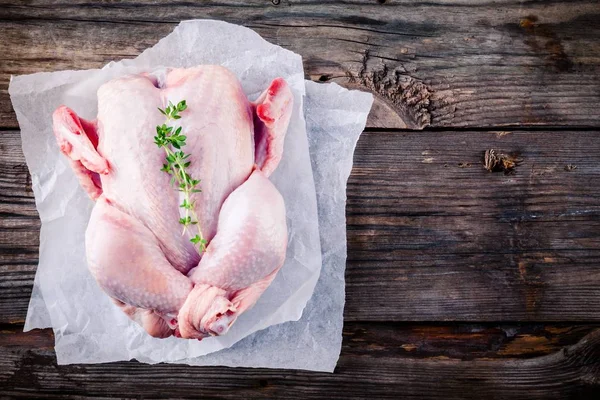 Pollo entero crudo orgánico sobre fondo de madera —  Fotos de Stock