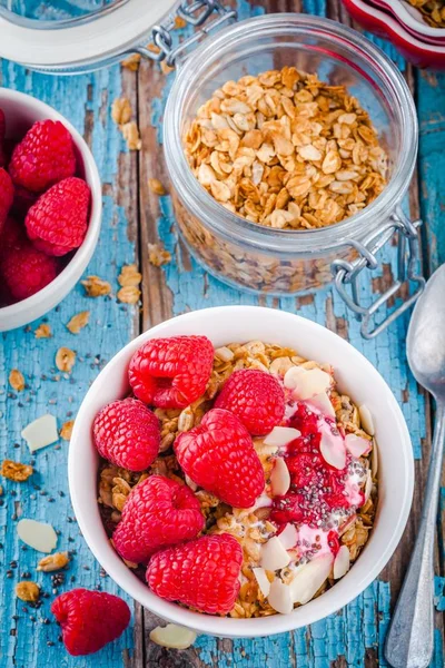 健康的早餐︰ 格兰诺拉麦片，酸奶，新鲜树莓、 杏仁和正大种子 — 图库照片