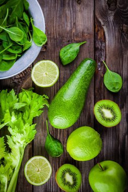 yeşil sebzeler: kivi, ıspanak, avokado, elma, limon, kereviz rustik ahşap arka plan üzerinde. Yukarıdan görüntülemek