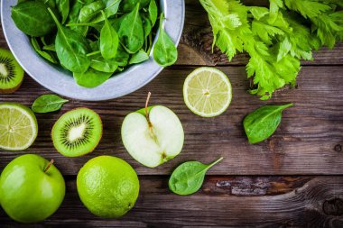 yeşil sebzeler: kivi, ıspanak, elma, limon, kereviz rustik ahşap arka plan üzerinde. Yukarıdan görüntülemek