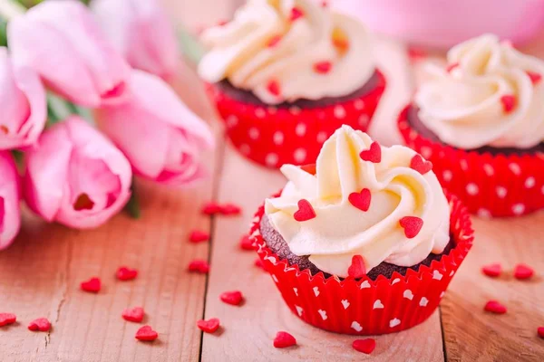 Homemade valentine cupcakes with red sugar hearts and pink tulips — Stock Photo, Image