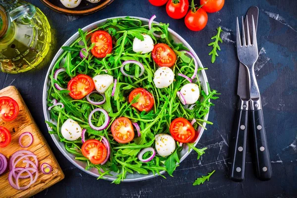 Insalata verde fresca con rucola, pomodori, mozzarella e cipolla rossa — Foto Stock