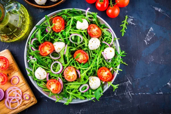 Insalata verde fresca con rucola, pomodori, mozzarella e cipolla rossa — Foto Stock