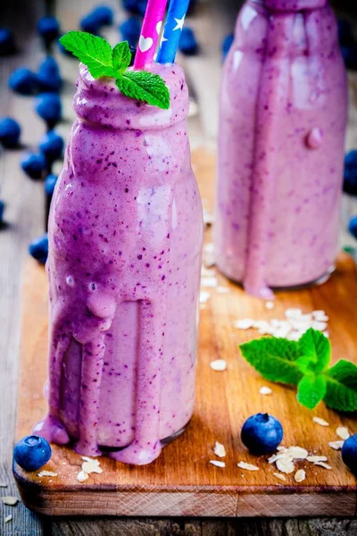 Blueberry smoothie in glass bottles closeup — Stock Photo, Image