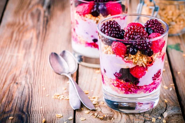 Desayuno: parfait de yogur con granola y frambuesa, arándanos, plátanos y mora congelada — Foto de Stock