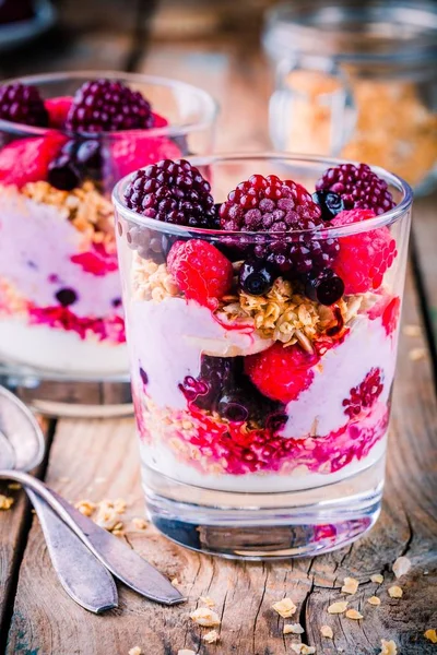Desayuno: parfait de yogur con granola y frambuesa, arándanos, plátanos y mora congelada — Foto de Stock