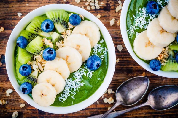 绿色的思慕雪碗与香蕉、 猕猴桃、 蓝莓、 格兰诺拉麦片和椰子 — 图库照片