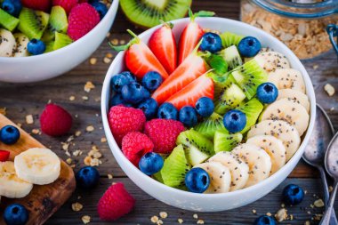 Kahvaltı kase: muz, kivi, ahududu, çilek, yaban mersini ve chia tohum ile granola