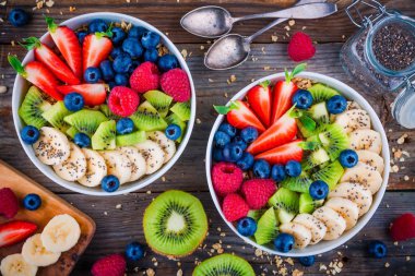 Kahvaltı kase: muz, kivi, ahududu, çilek, yaban mersini ve chia tohum ile granola