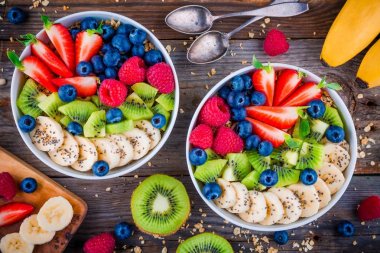 Kahvaltı kase: muz, kivi, ahududu, çilek, yaban mersini ve chia tohum ile granola