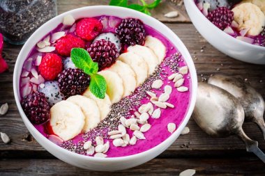 Muz, ahududu, pitaya, böğürtlen, badem, ayçiçeği ve chia tohumu ile Blueberry smoothie kase 